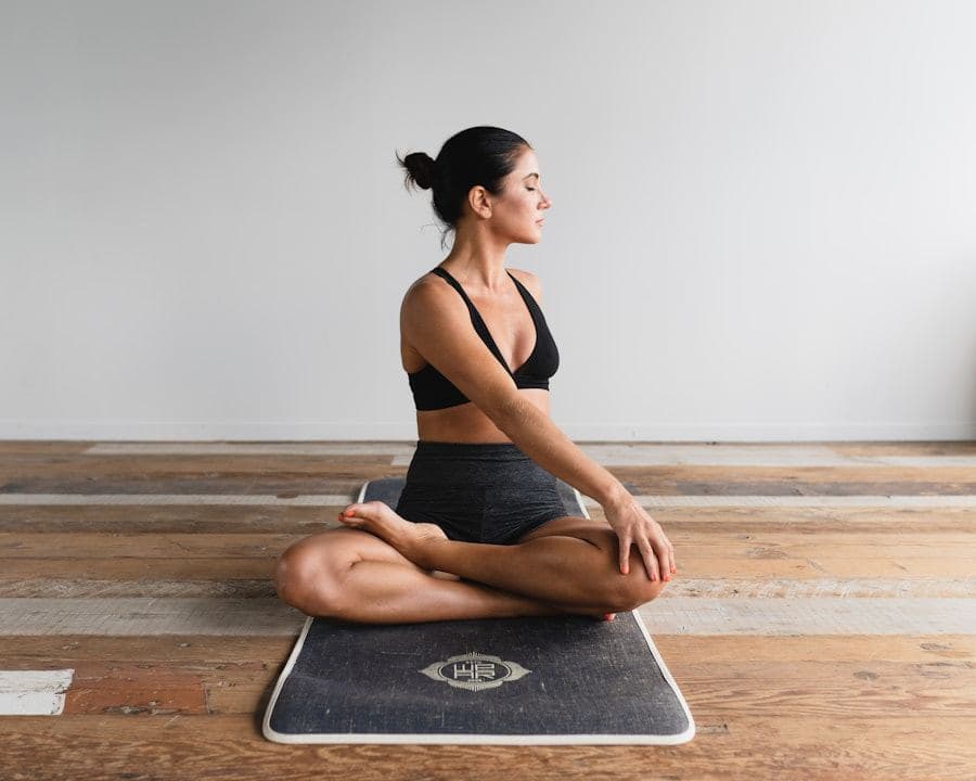 Member sitting cross-legged on a mat during a mobility session