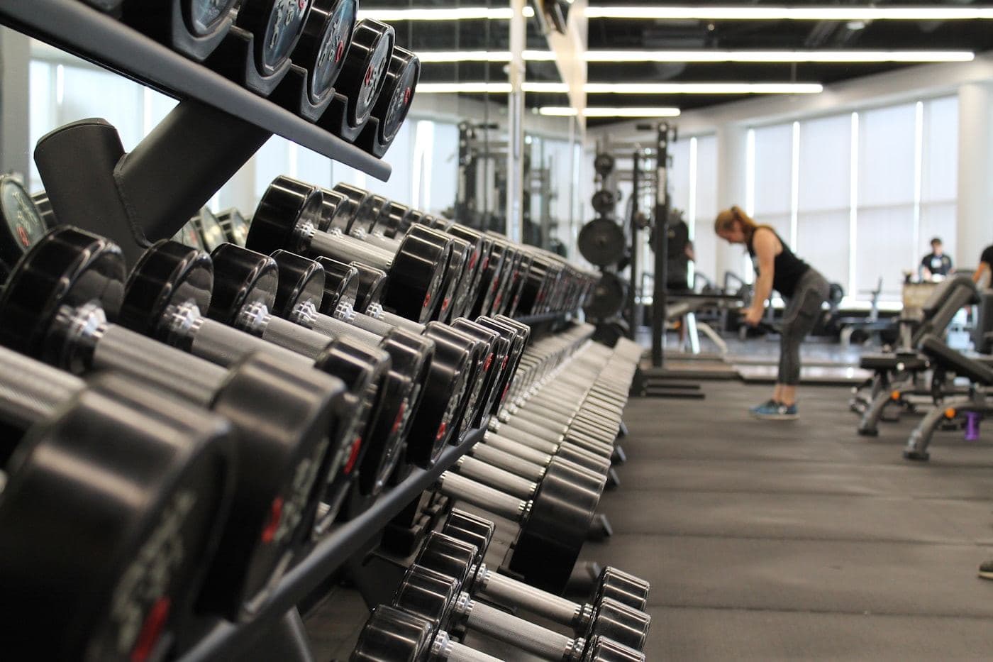 Free-weight studio with dumbbell racks beside a window wall