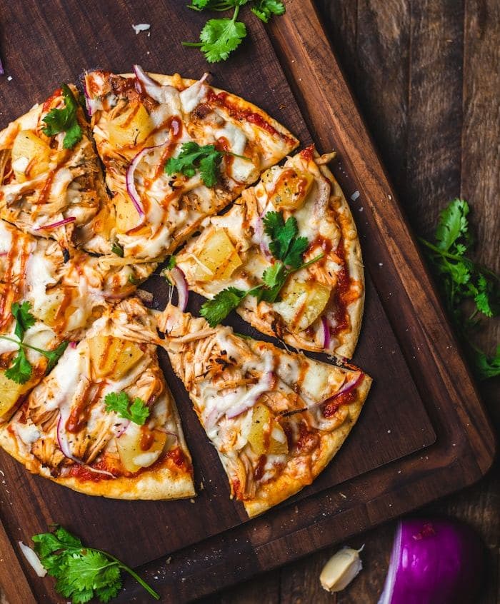 Wood-fired pizza sliced on a rustic wooden board