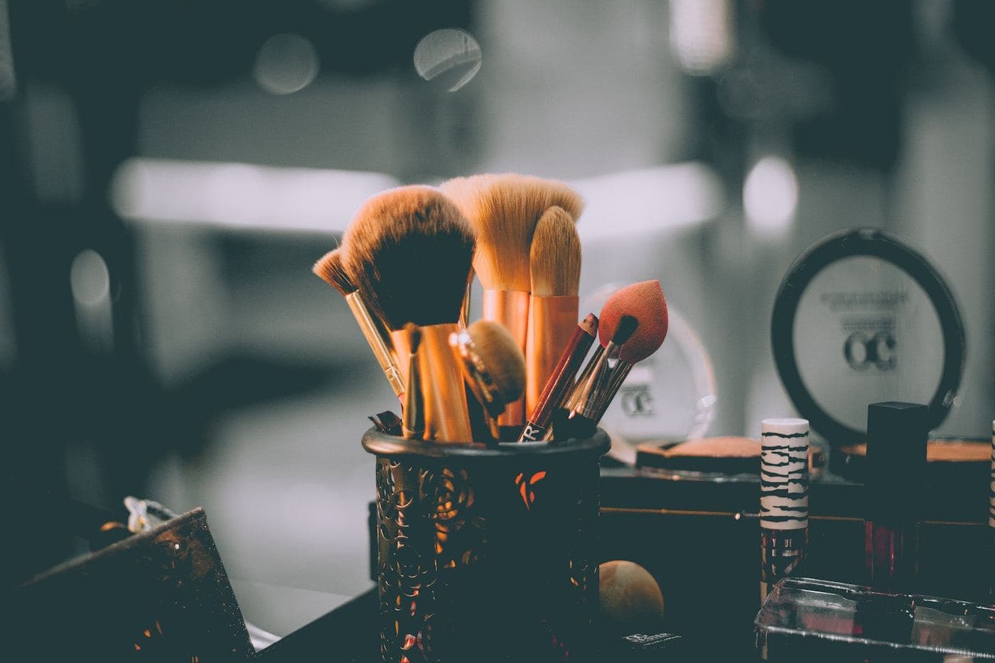 Makeup brushes in a pot on a studio counter