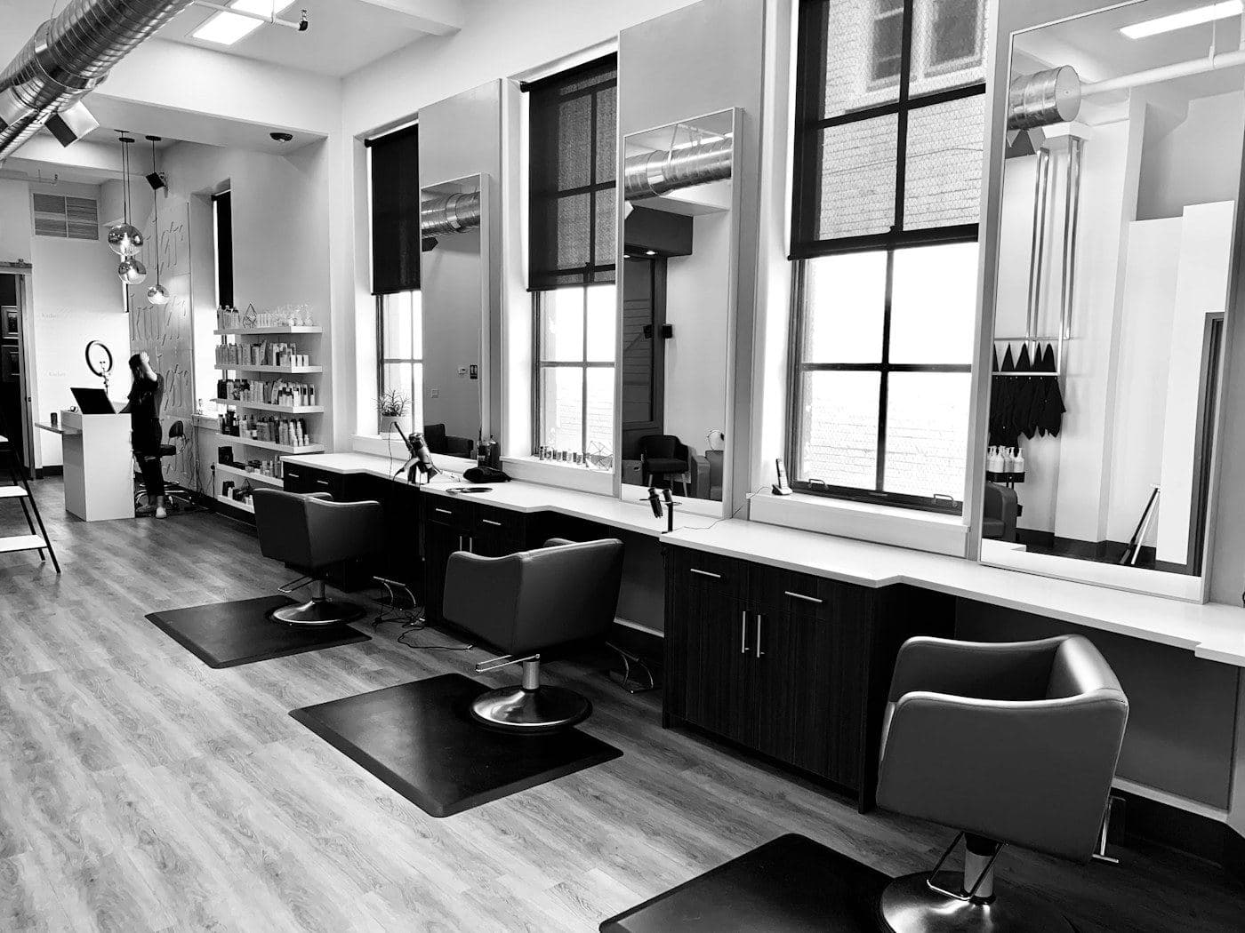 Row of salon chairs beside tall studio windows