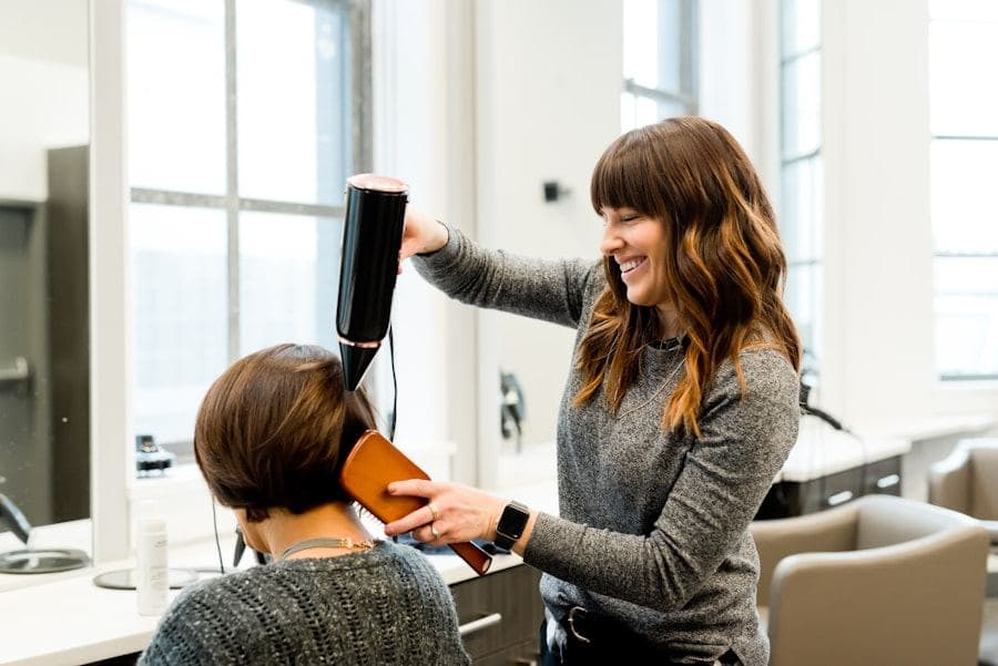 Stylist blow-drying and styling a client's hair in a bright salon