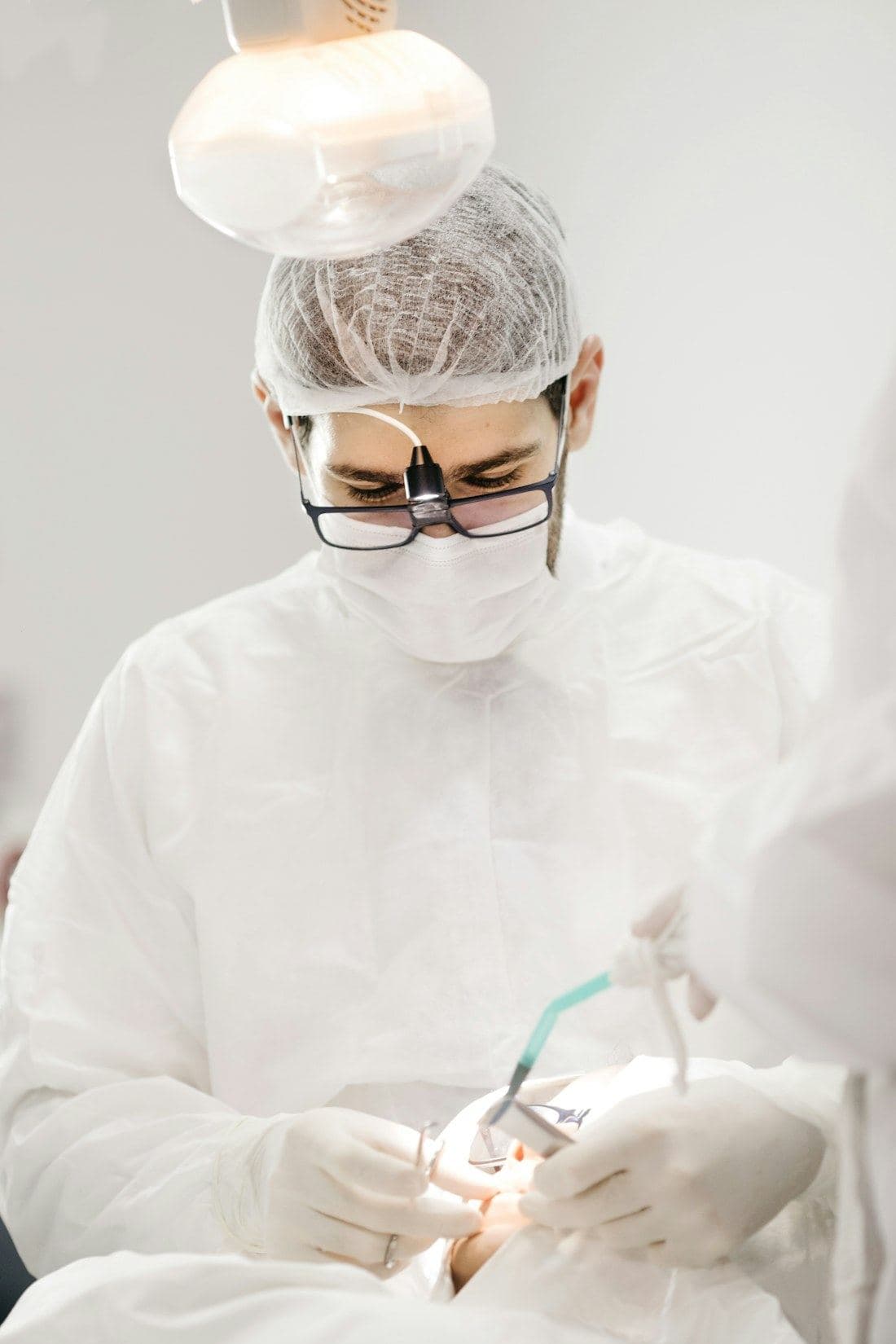Clinician in full protective equipment working with a handpiece