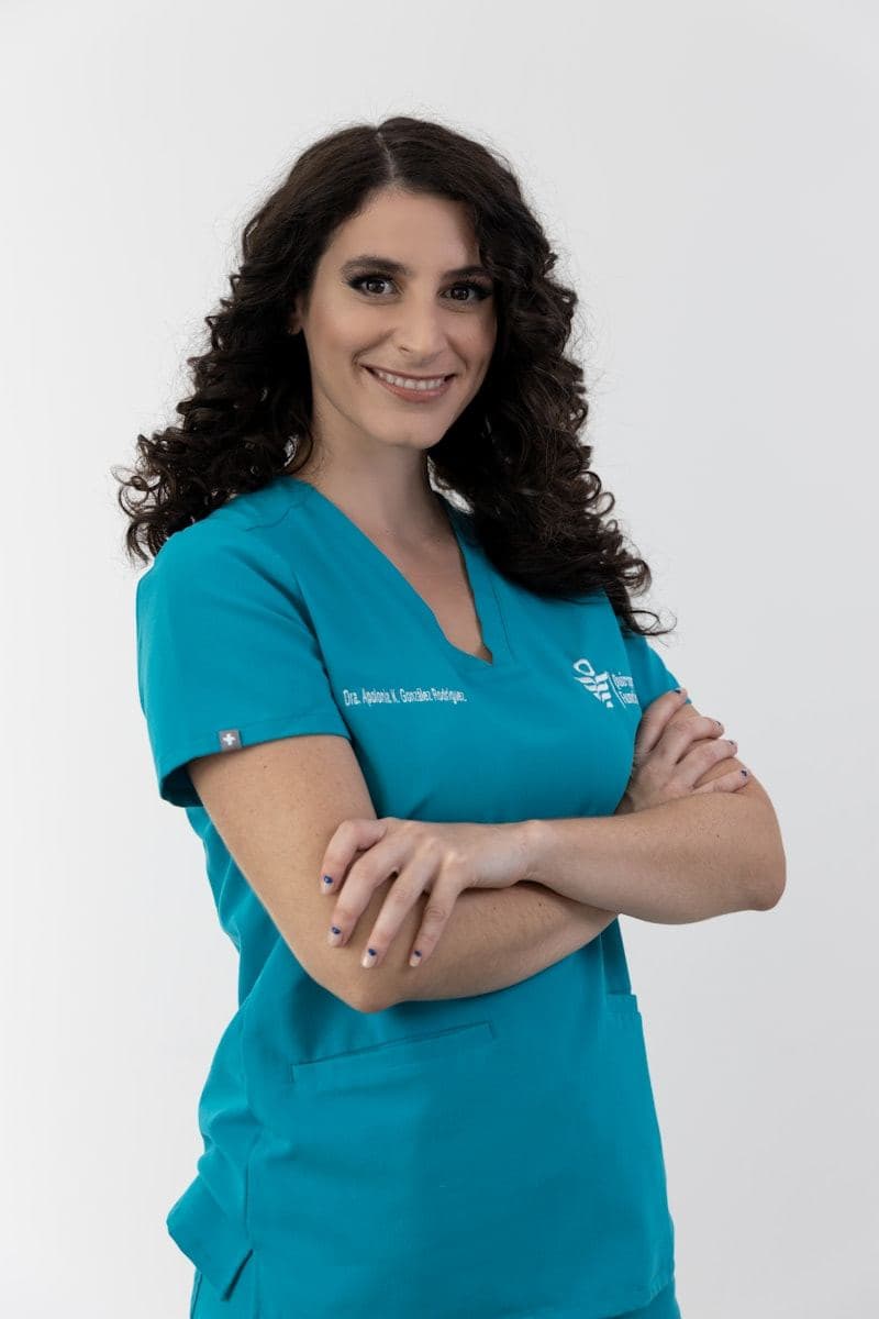 Clinician in teal scrubs with arms folded