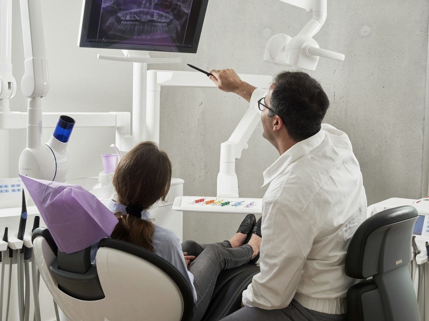 Dentist reviewing a patient's X-ray on a screen chairside