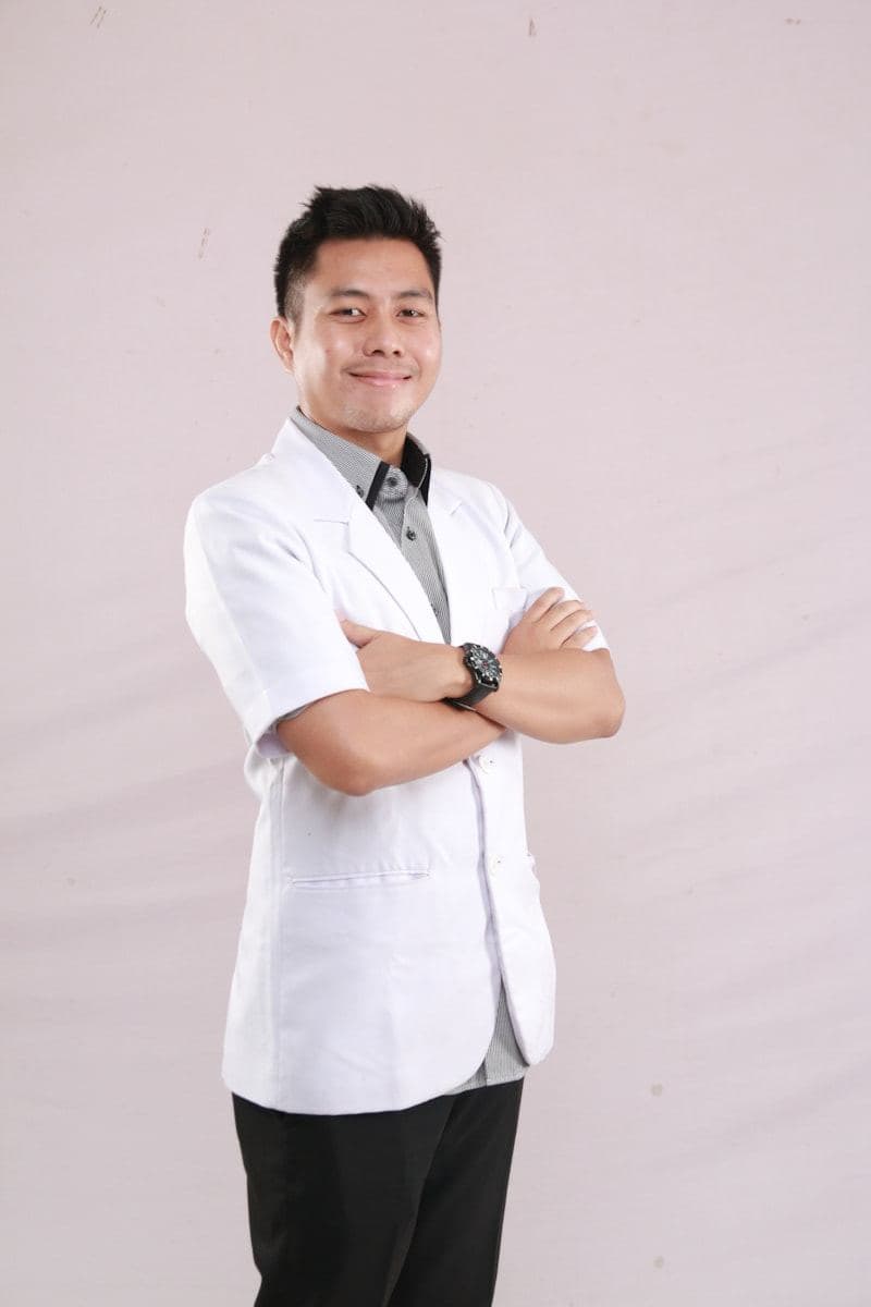 Clinician in a white coat with arms folded