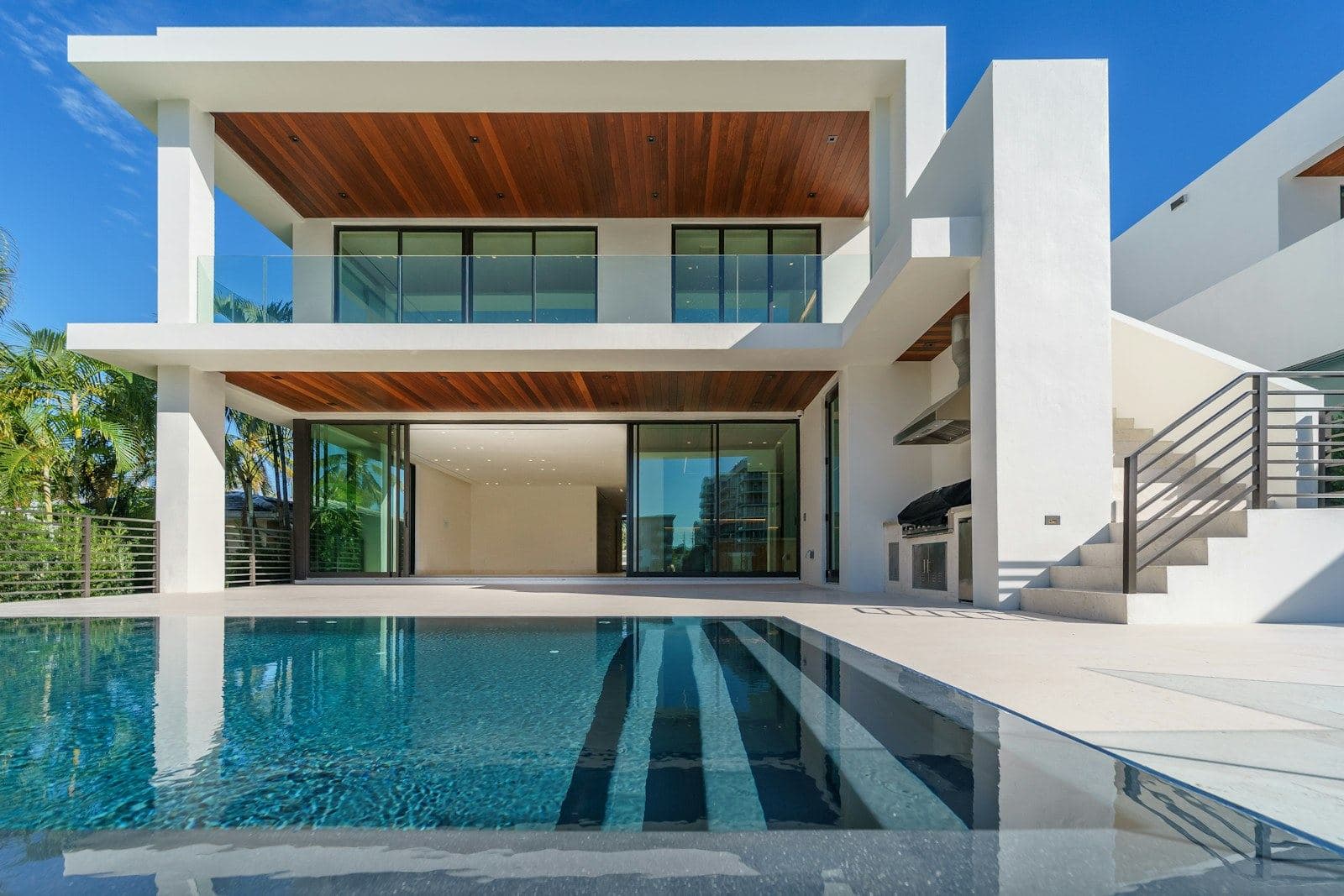 Modern glass house lit from within at dusk