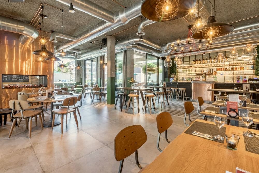 Warmly lit dining room with wooden tables and pendant lamps
