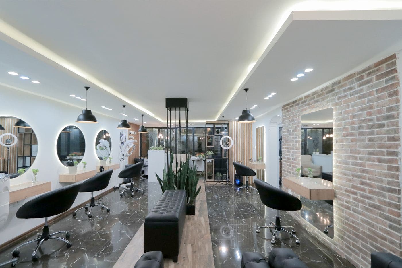Bright salon interior with styling chairs and a brick wall